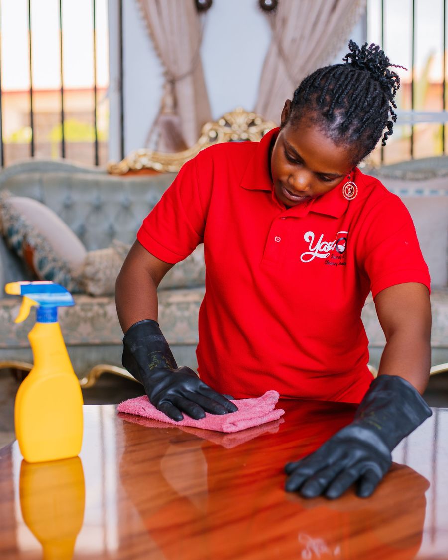 Cleaner wiping a table in gloves